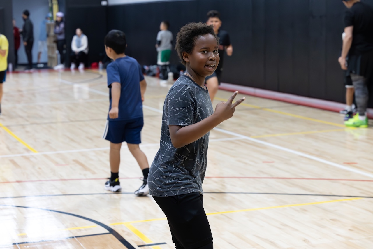 A young player smiling on the Hoop Legends court during an Open Run